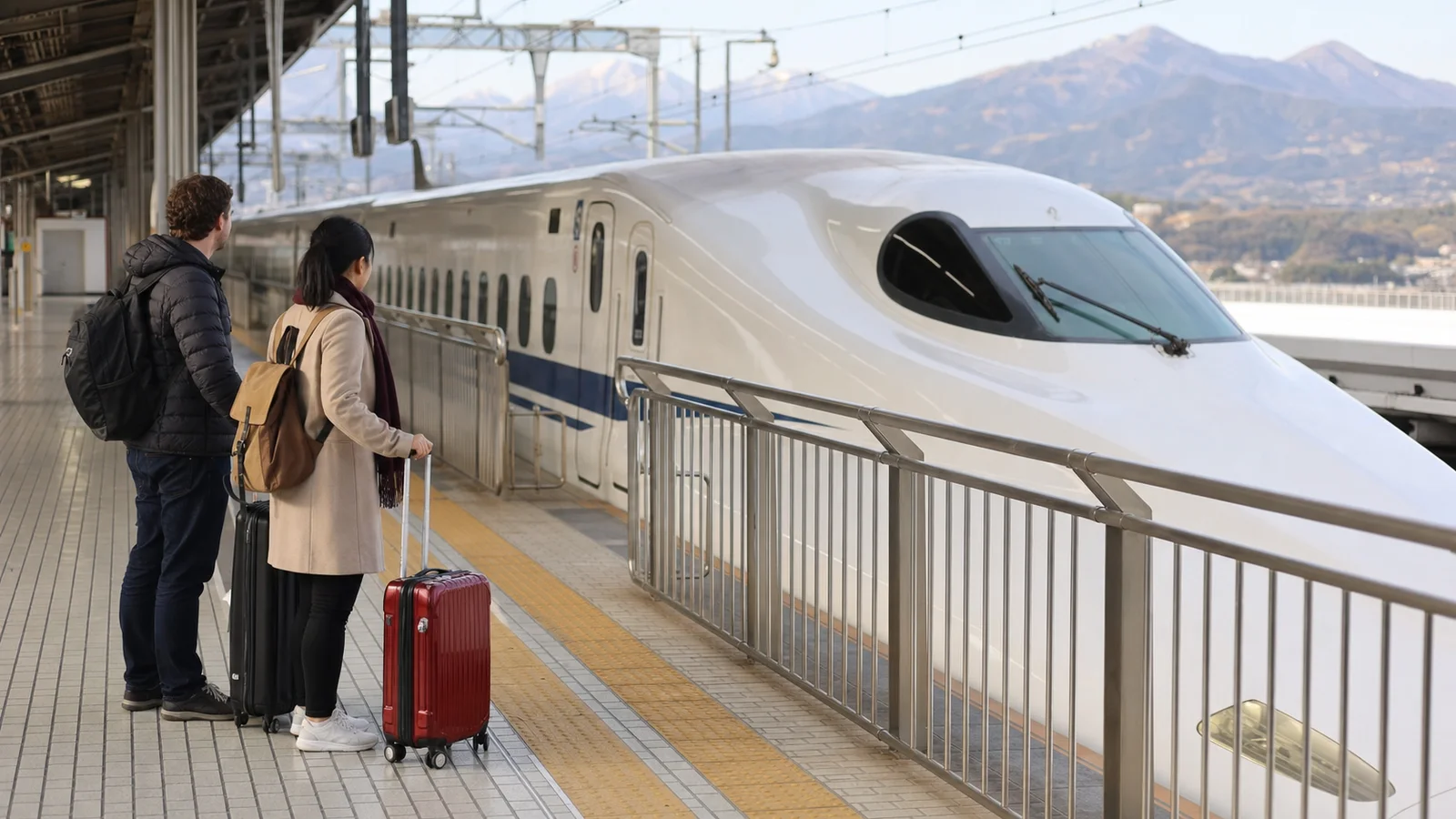 Andén de Odawara con un tren bala y viajeros con equipaje ligero