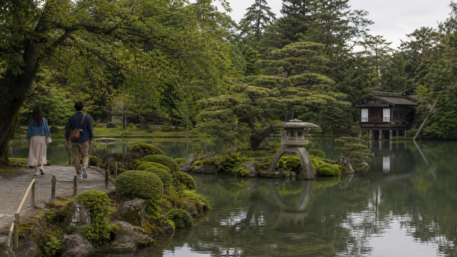Jardín Kenrokuen de Kanazawa con pinos, agua y una casa de té